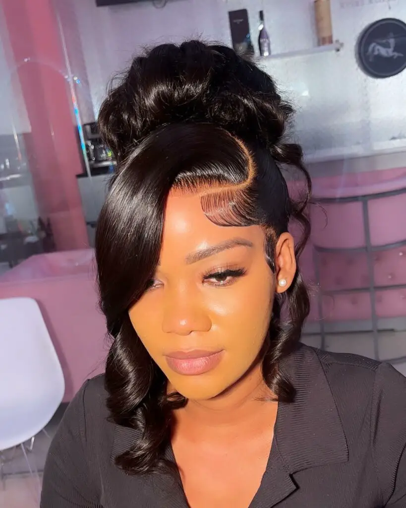 Creative updo with a side-swept bang and soft waves for prom