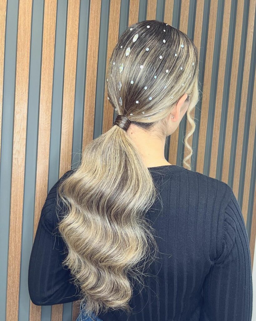 Shiny low ponytail adorned with twinkling hair gems