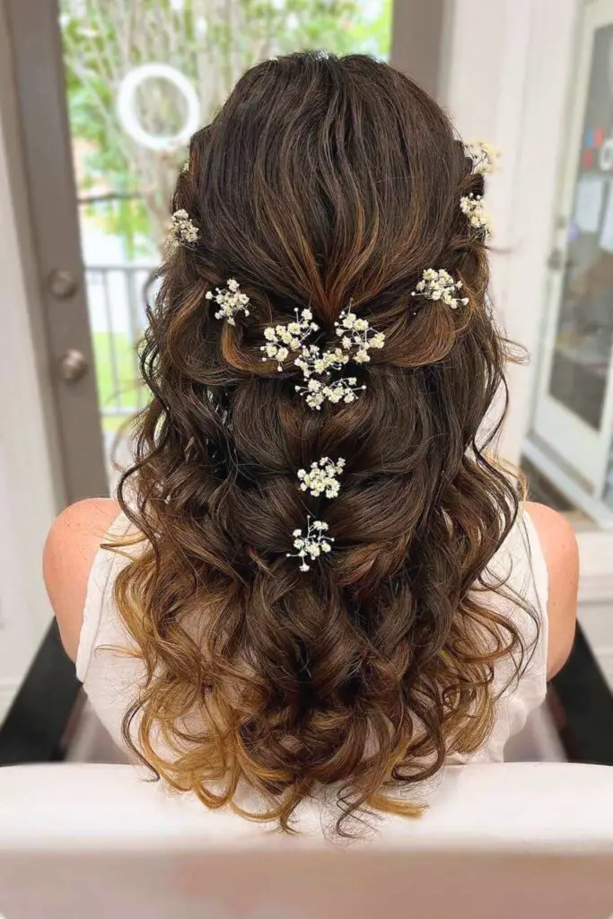 Gorgeous half-up braided hairstyle adorned with fresh flowers, adding a whimsical and romantic touch